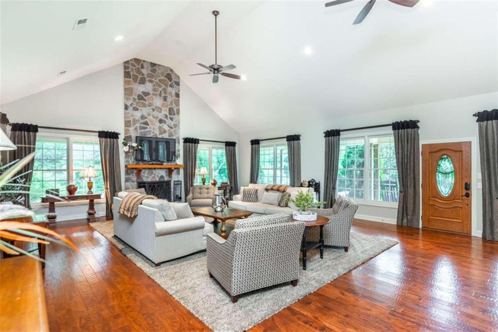 565 Owens Gin Road Northeast Calhoun, GA 30701 - Photo 39 of 80 a living room with furniture a fireplace and a chandelier