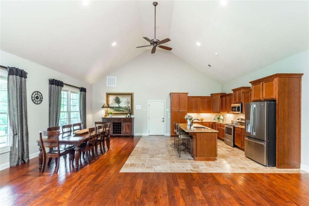 565 Owens Gin Road Northeast Calhoun, GA 30701 - Photo 43 of 80 a kitchen with stainless steel appliances granite countertop a refrigerator stove top oven dining table and chairs