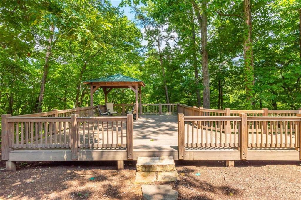 565 Owens Gin Road Northeast Calhoun, GA 30701 - Photo 55 of 80 a view of a deck with a table and chair under an umbrella