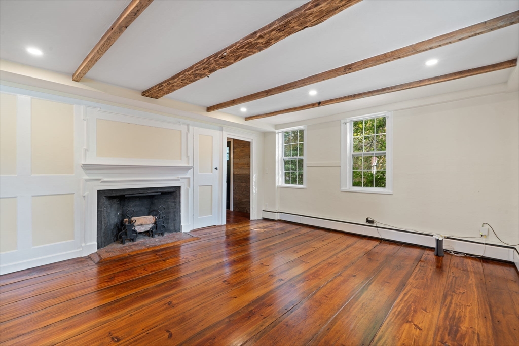 132 Maple Avenue Atkinson, NH 03811 - Photo 17 of 41 an empty room with wooden floor fireplace and windows