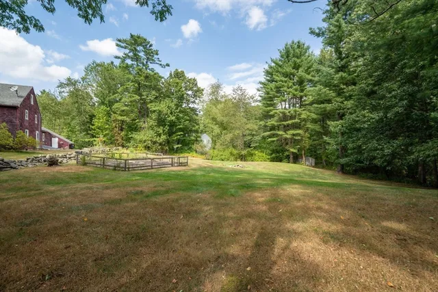 a view of a brick house with a yard and plants