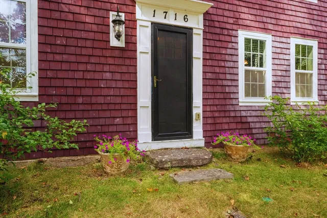 a view of a brick house with a flower garden