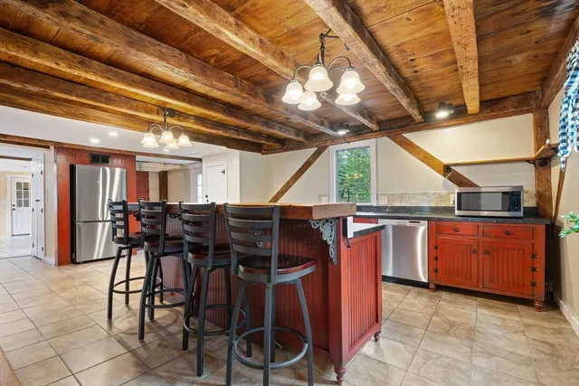 a large kitchen with stainless steel appliances granite countertop a sink and cabinets
