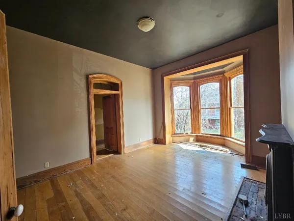 a view of an empty room with glass door and wooden floor