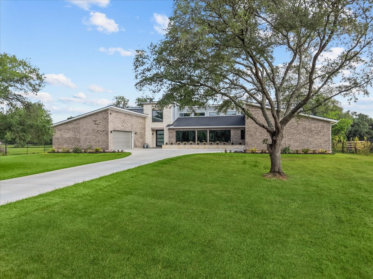 7627 Scott Avenue Manvel, TX 77578 - Photo 6 of 50 This 5,500 sq. ft. single-story masterpiece offers a grand sense of arrival with its manicured lawn and iconic oak-canopied grounds.