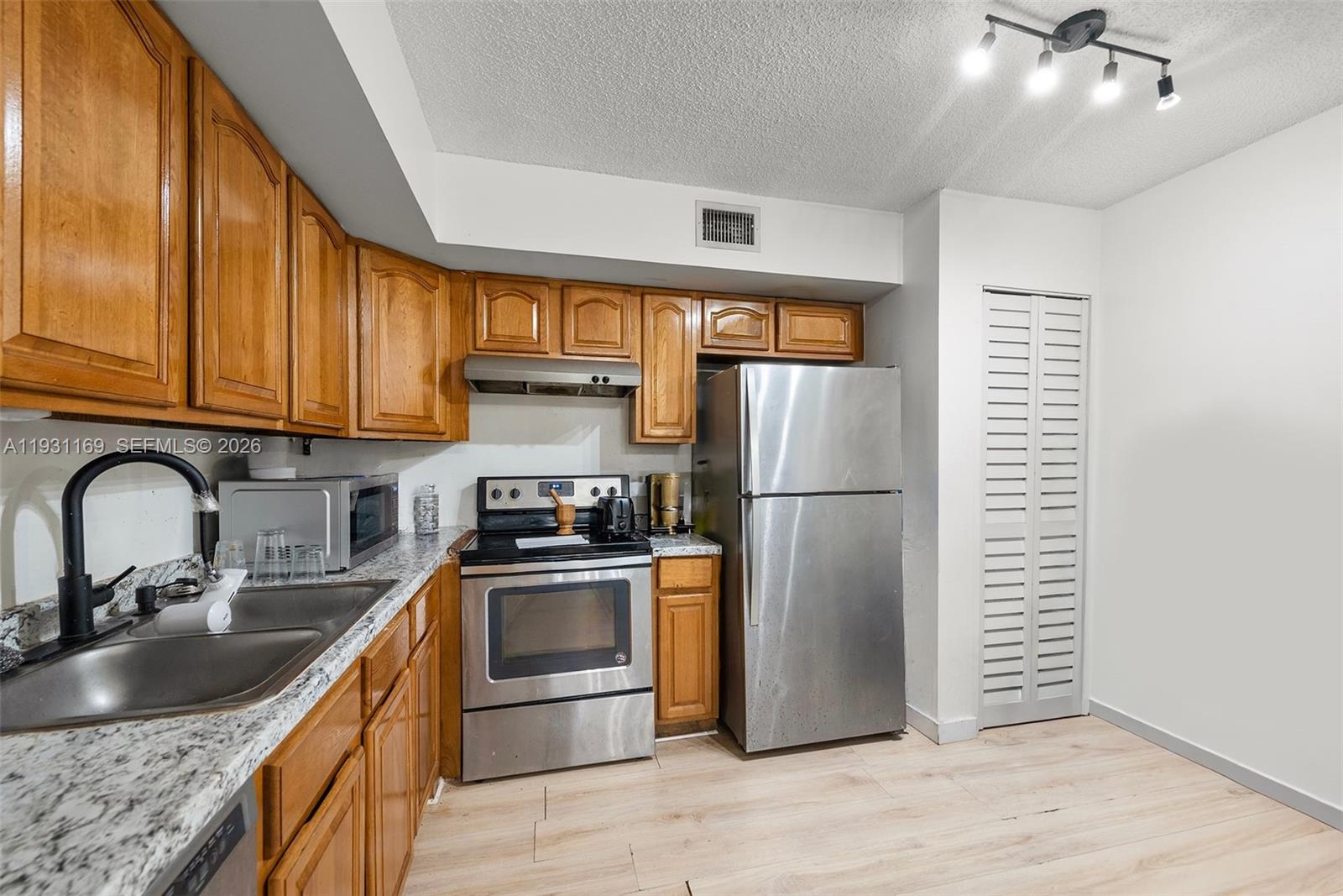 3700 North 56th Avenue, Unit 1012 Hollywood, FL 33021 - Photo 6 of 15 a kitchen with stainless steel appliances granite countertop a refrigerator sink and stove
