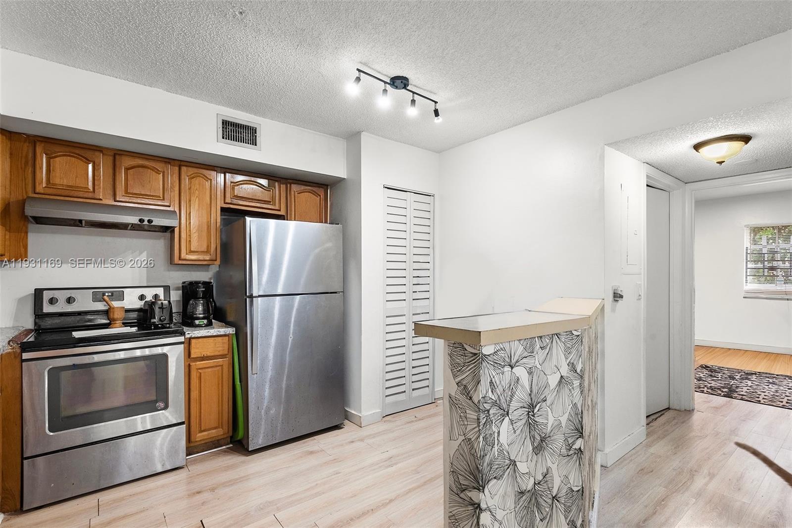 3700 North 56th Avenue, Unit 1012 Hollywood, FL 33021 - Photo 7 of 15 a kitchen with stainless steel appliances granite countertop a stove a refrigerator and a refrigerator