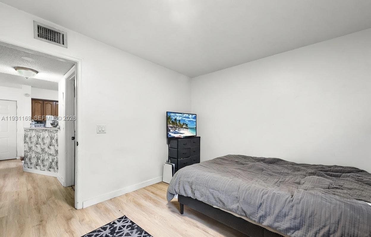 3700 North 56th Avenue, Unit 1012 Hollywood, FL 33021 - Photo 9 of 15 a bedroom with a bed and wooden floor