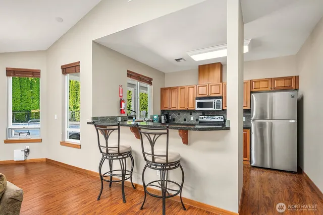a kitchen with a table chairs refrigerator and a window