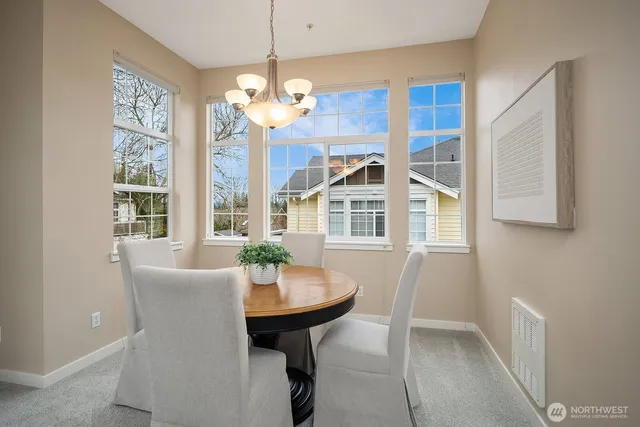 a view of a dining room with furniture a chandelier and a window