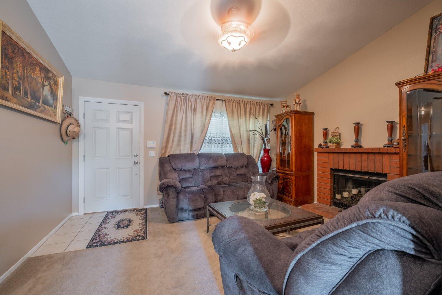 44628 Shadowcrest Drive Lancaster, CA 93536 - Photo 5 of 23 a living room with furniture a fireplace and a flat screen tv