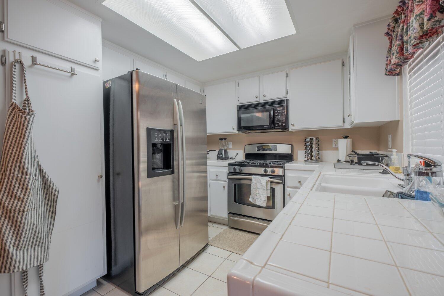 44628 Shadowcrest Drive Lancaster, CA 93536 - Photo 7 of 23 a kitchen with stainless steel appliances a refrigerator sink and microwave
