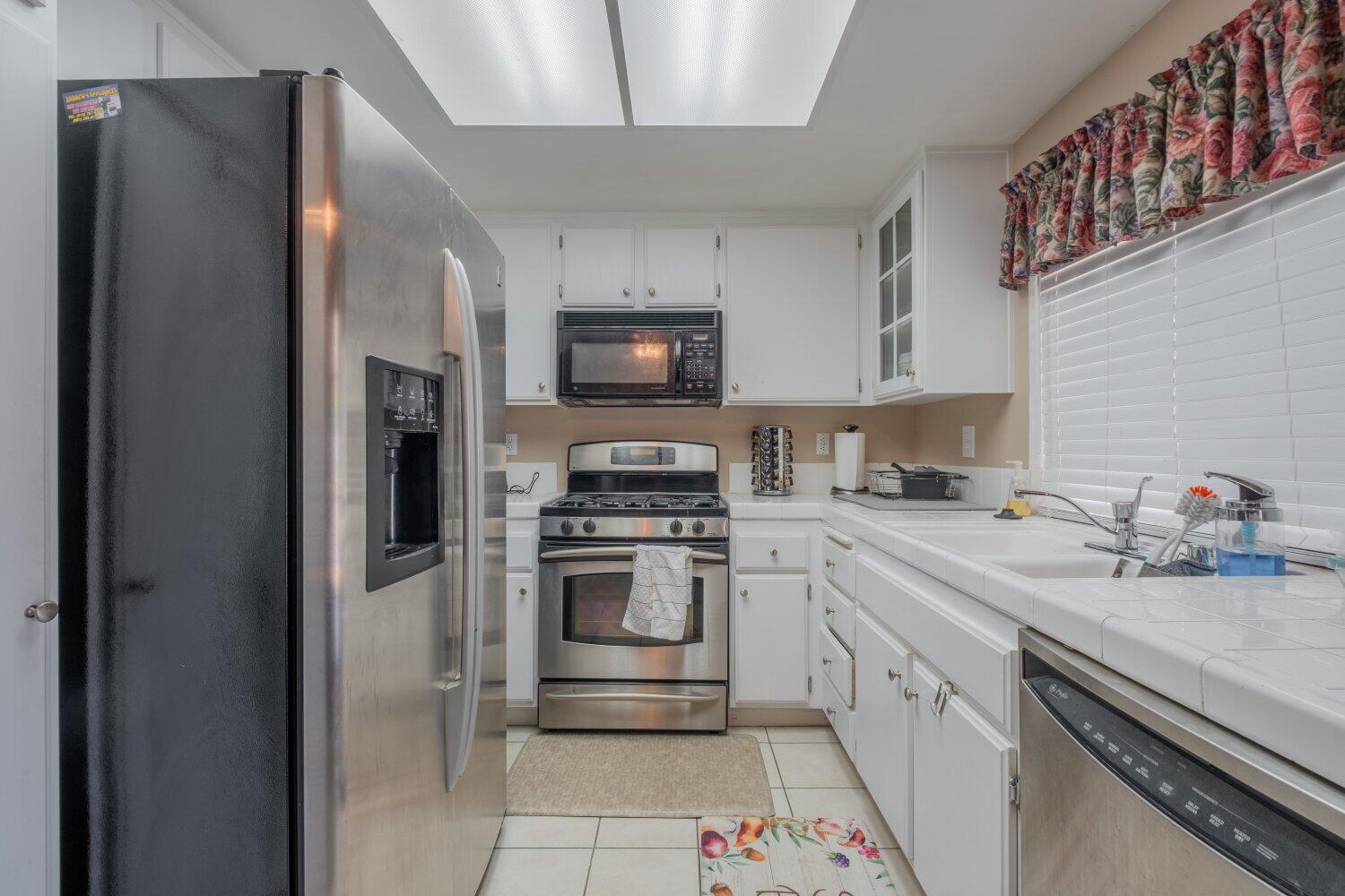 44628 Shadowcrest Drive Lancaster, CA 93536 - Photo 8 of 23 a kitchen with stainless steel appliances granite countertop a refrigerator sink and stove