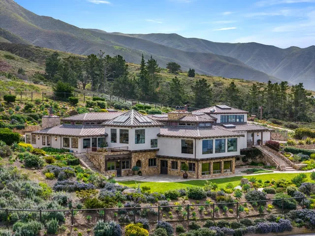 a front view of a building with a mountain in the background