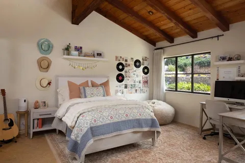 a living room with furniture a flat screen tv and a large window