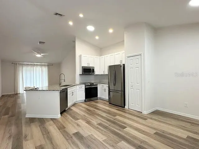 a kitchen with stainless steel appliances a refrigerator and a stove top oven