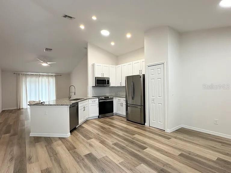 1737 North Lakewood Avenue Ocoee, FL 34761 - Photo 3 of 16 a kitchen with stainless steel appliances a refrigerator and a stove top oven