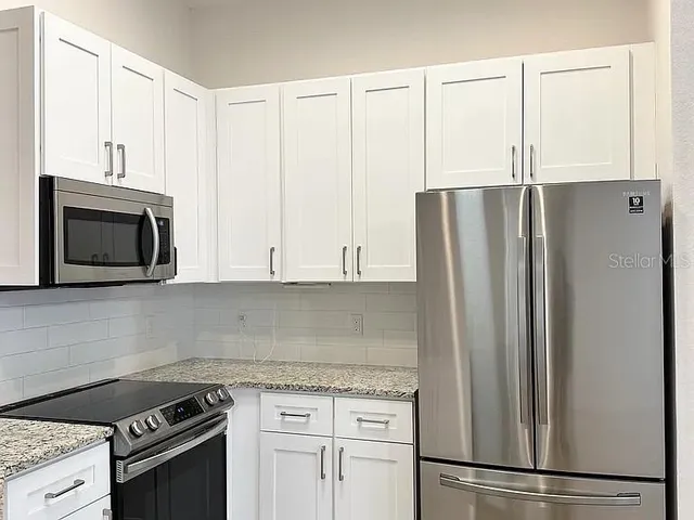 a kitchen with appliances cabinets and a counter top space