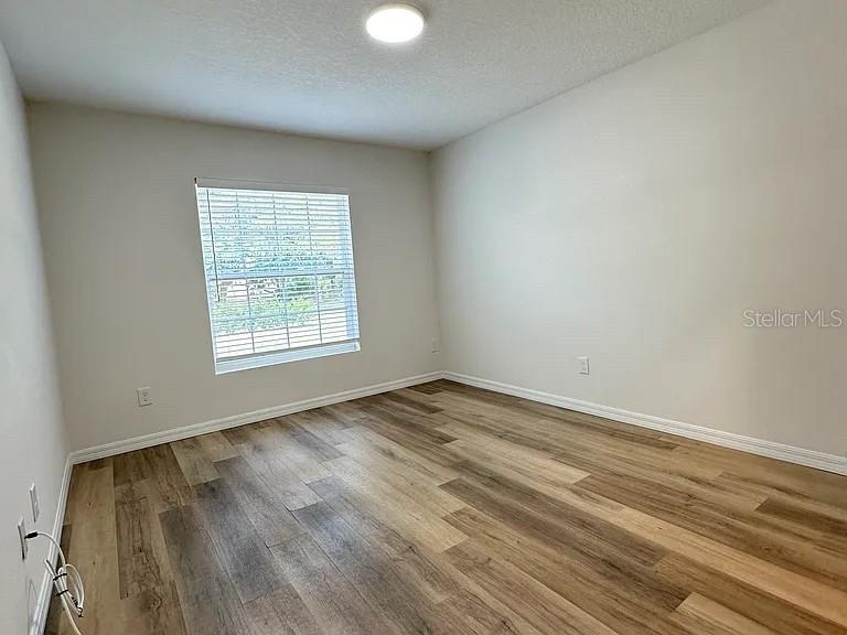 1737 North Lakewood Avenue Ocoee, FL 34761 - Photo 8 of 16 an empty room with wooden floor and windows
