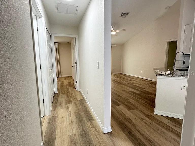 1737 North Lakewood Avenue Ocoee, FL 34761 - Photo 9 of 16 a view of a hallway with wooden floor and a bathroom