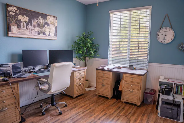 a view of a workspace with furniture and a window