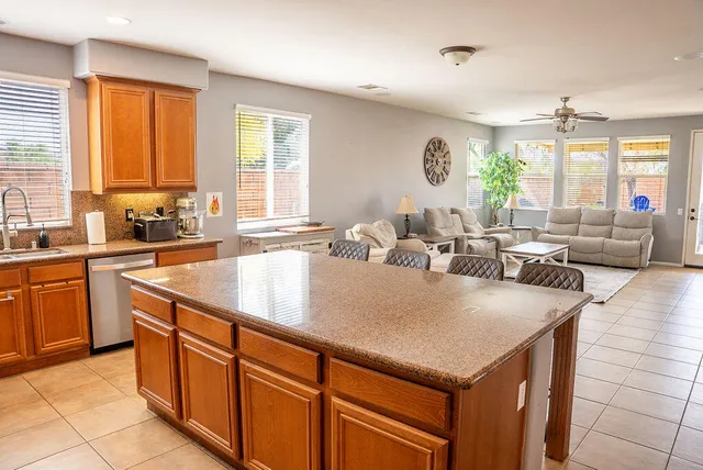 a large kitchen with kitchen island a large counter space windows and a sink
