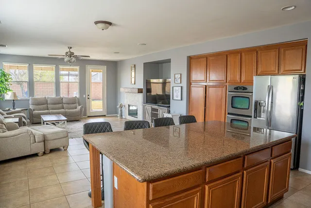 a kitchen with stainless steel appliances granite countertop a refrigerator a stove and a sink