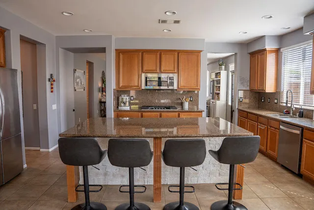 a kitchen with stainless steel appliances granite countertop a sink and a refrigerator