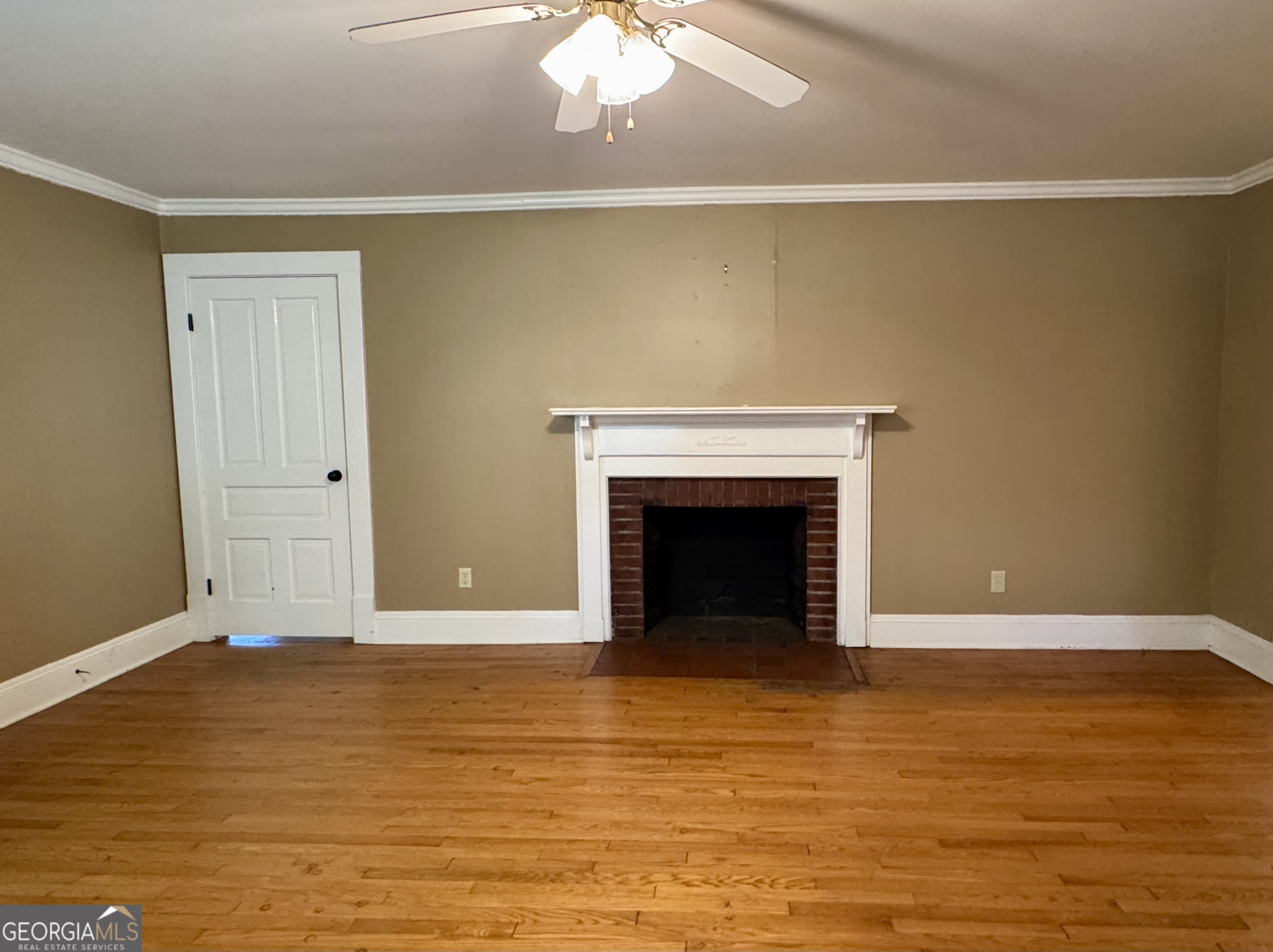 324 North Rhodes Street Union Point, GA 30669 - Photo 16 of 94 a view of an empty room with wooden floor and a fireplace