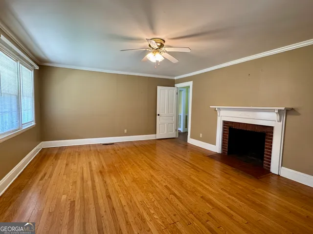 an empty room with a window and a fan