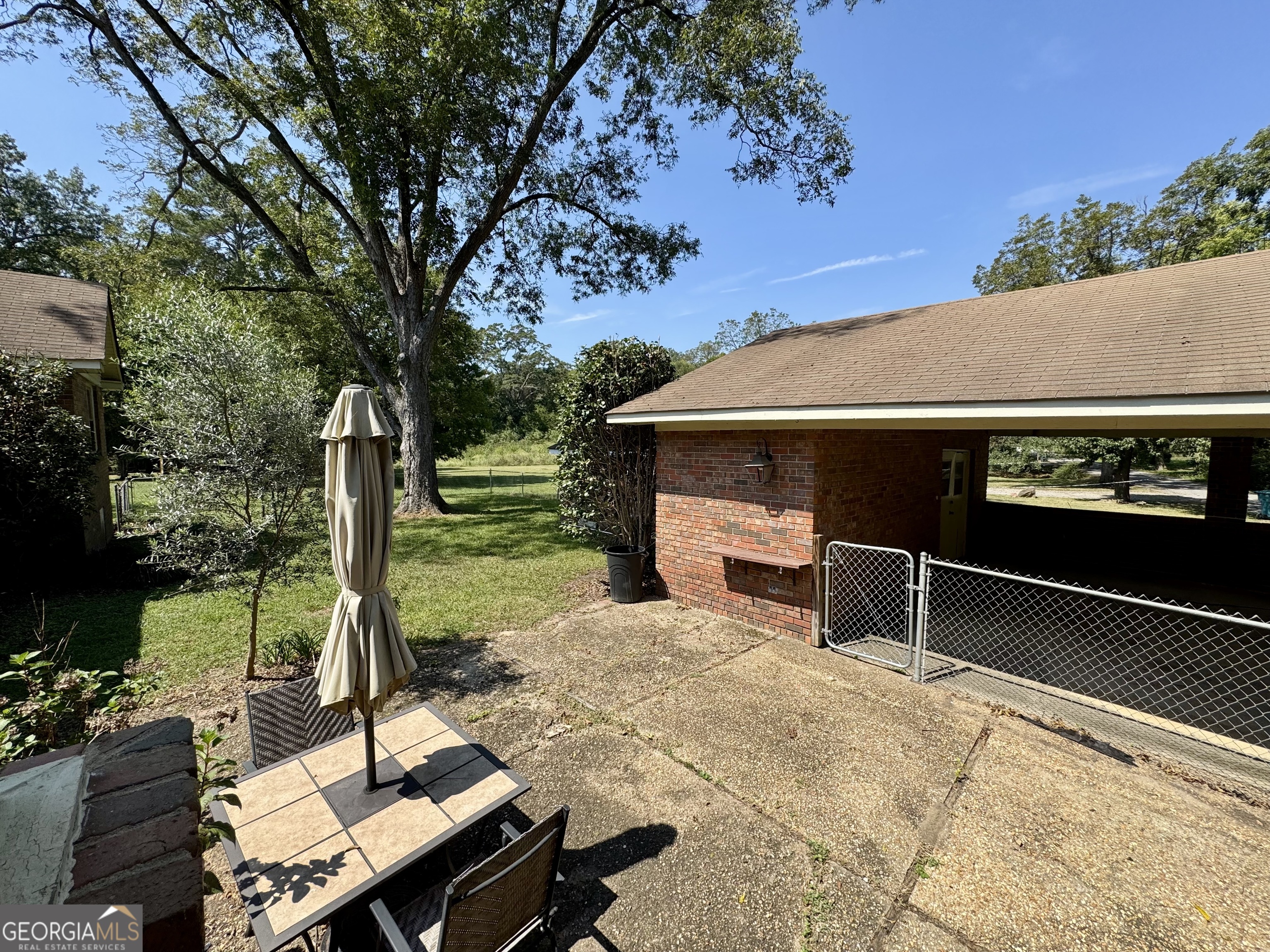 324 North Rhodes Street Union Point, GA 30669 - Photo 86 of 94 a view of a patio with table and chairs potted plants and a large tree