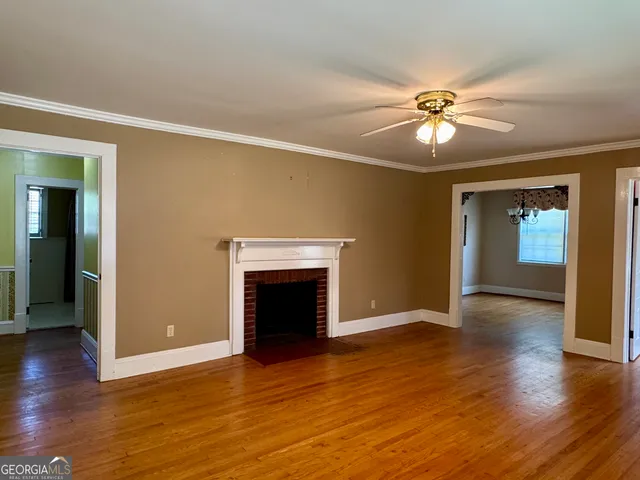 a view of a dining room with furniture a chandelier and wooden floor