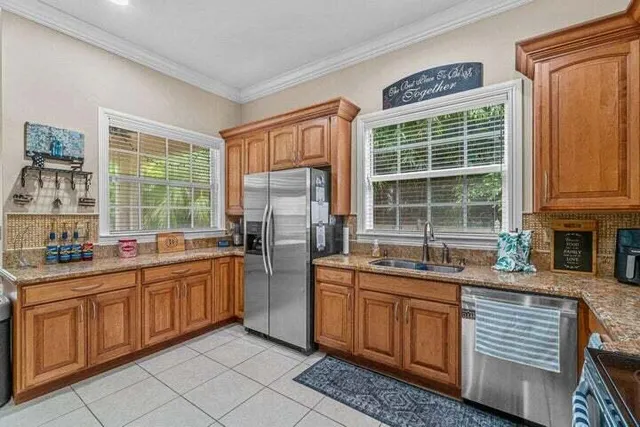 a kitchen with stainless steel appliances granite countertop a stove a sink and a refrigerator