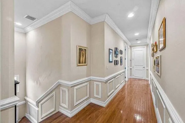 a view of a hallway with entryway and wooden floor