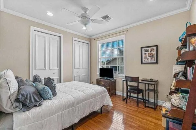 a spacious bedroom with a bed a table and a potted plant
