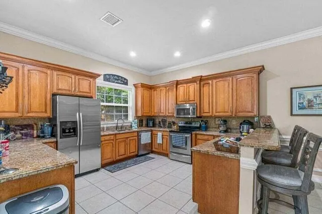 a kitchen with stainless steel appliances granite countertop sink stove top oven and cabinets