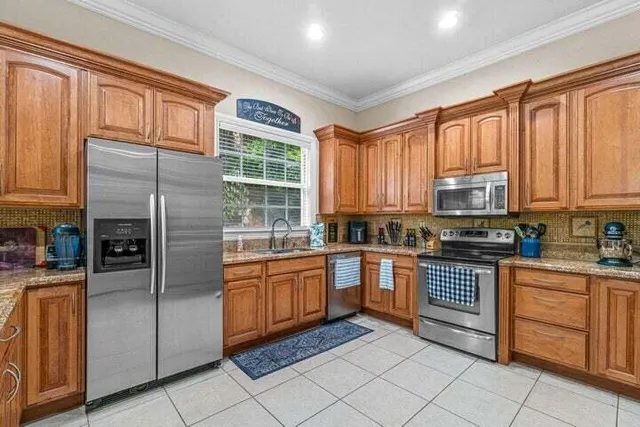 a kitchen with stainless steel appliances granite countertop a refrigerator and cabinets