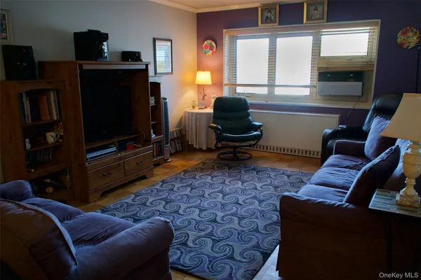 a living room with furniture a flat screen tv and a window