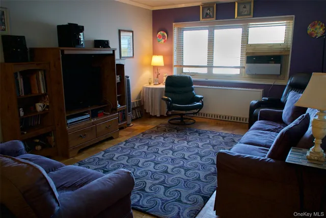 a living room with furniture a flat screen tv and a window