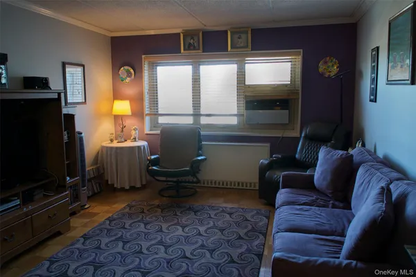 a living room with furniture a flat screen tv and a window