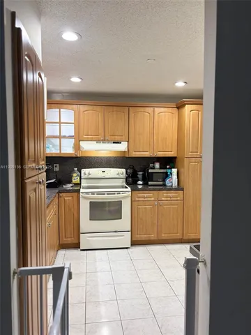 a kitchen with granite countertop a sink and a stove