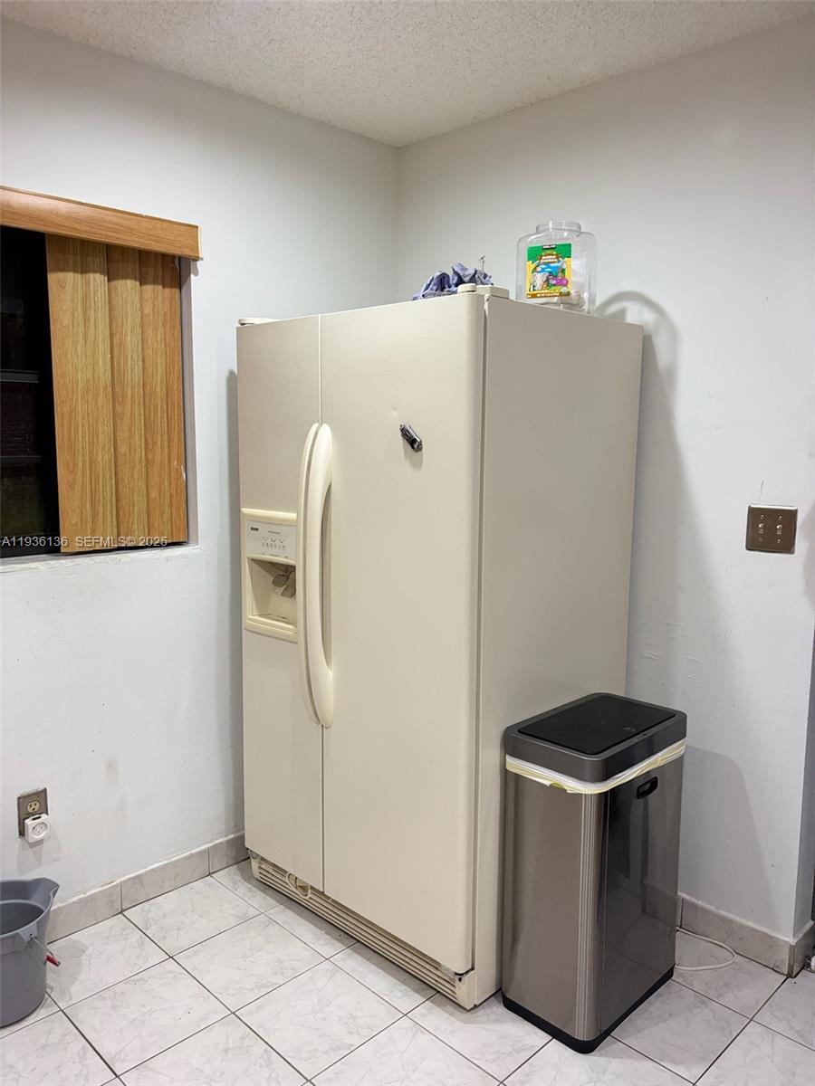 6460 Northwest 192nd Terrace, Unit 6460 Hialeah, FL 33015 - Photo 25 of 42 a kitchen with a refrigerator and cabinets