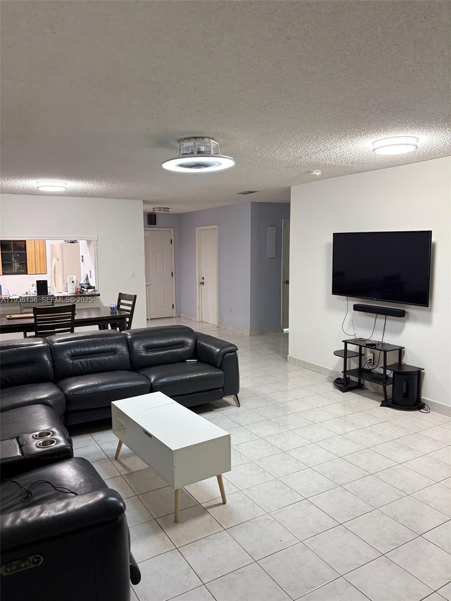 6460 Northwest 192nd Terrace, Unit 6460 Hialeah, FL 33015 - Photo 29 of 42 a living room with furniture and a flat screen tv