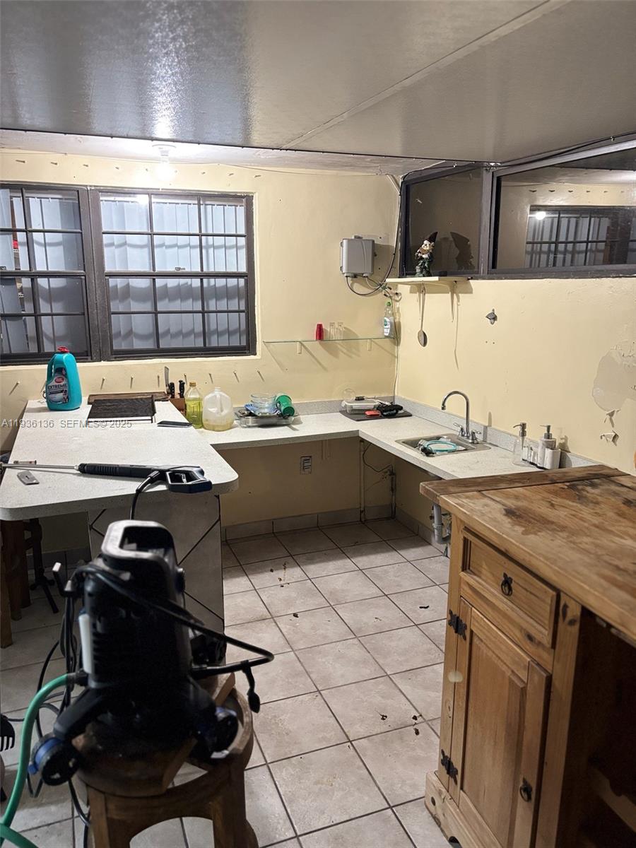 6460 Northwest 192nd Terrace, Unit 6460 Hialeah, FL 33015 - Photo 37 of 42 a kitchen with a sink a stove a counter space and cabinets