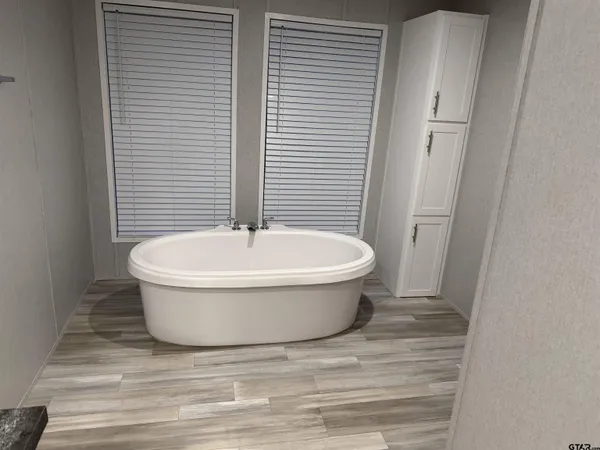 a white bath tub sitting in a bathroom next to a toilet
