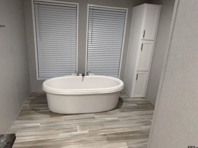 a white bath tub sitting in a bathroom next to a toilet