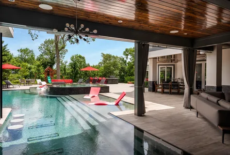a kitchen with stainless steel appliances a sink a large window and a dining table