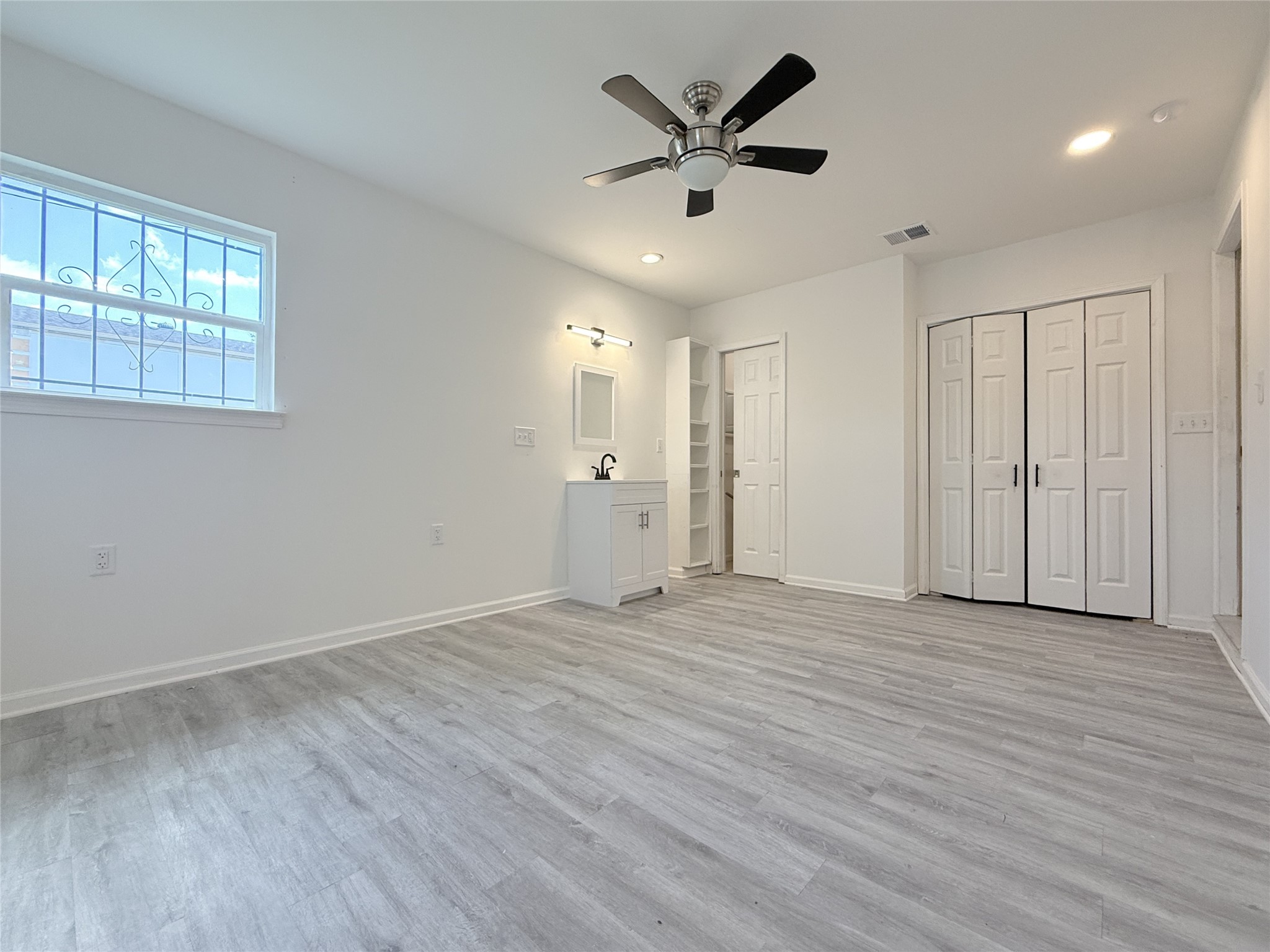 1922 Tabor Street Houston, TX 77009 - Photo 9 of 24 The primary bedroom offers recessed lighting & ceiling fan w/light fixture. Next to the vanity is built-in linen storage & a pocket door which opens to the toilet & shower.