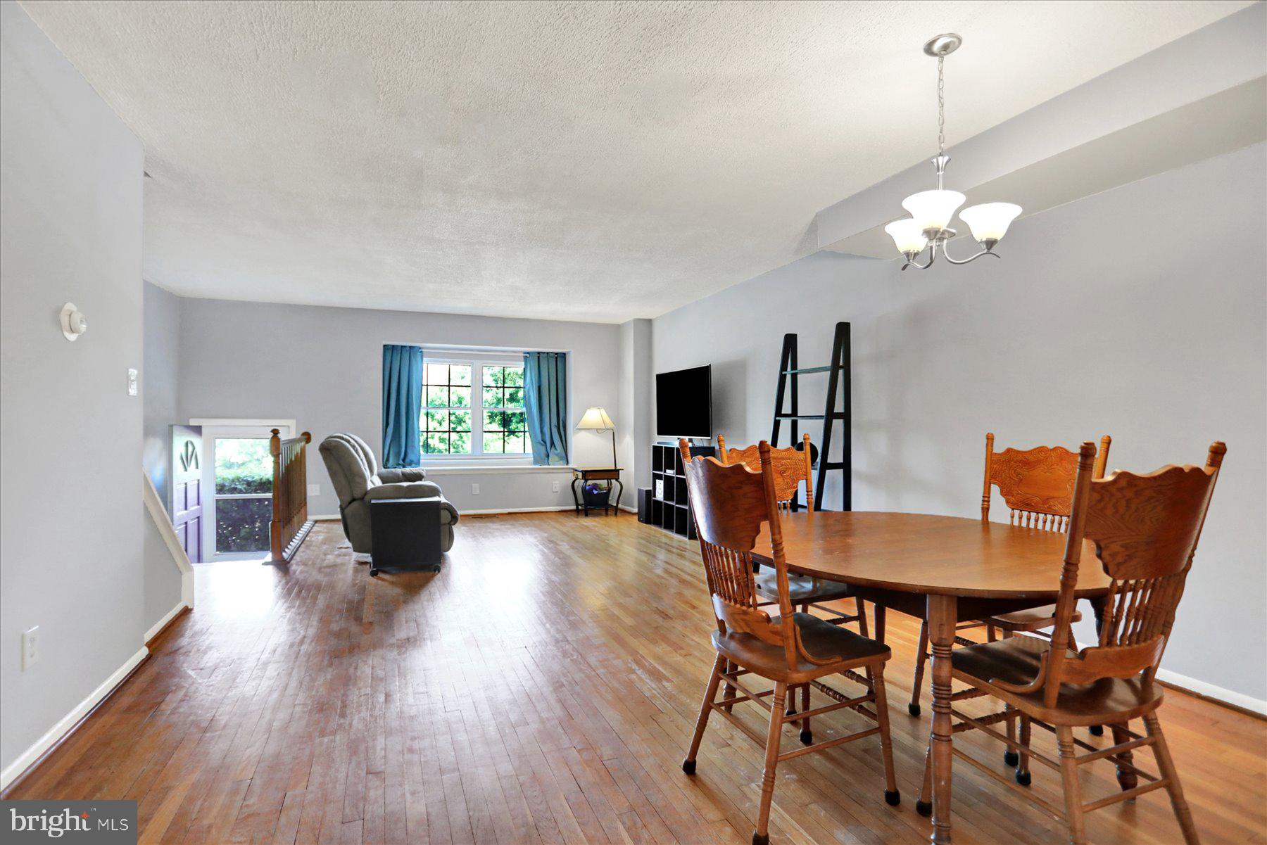 959 Elm Road Baltimore, MD 21227 - Photo 2 of 27 a view of a dining room with furniture a chandelier and wooden floor