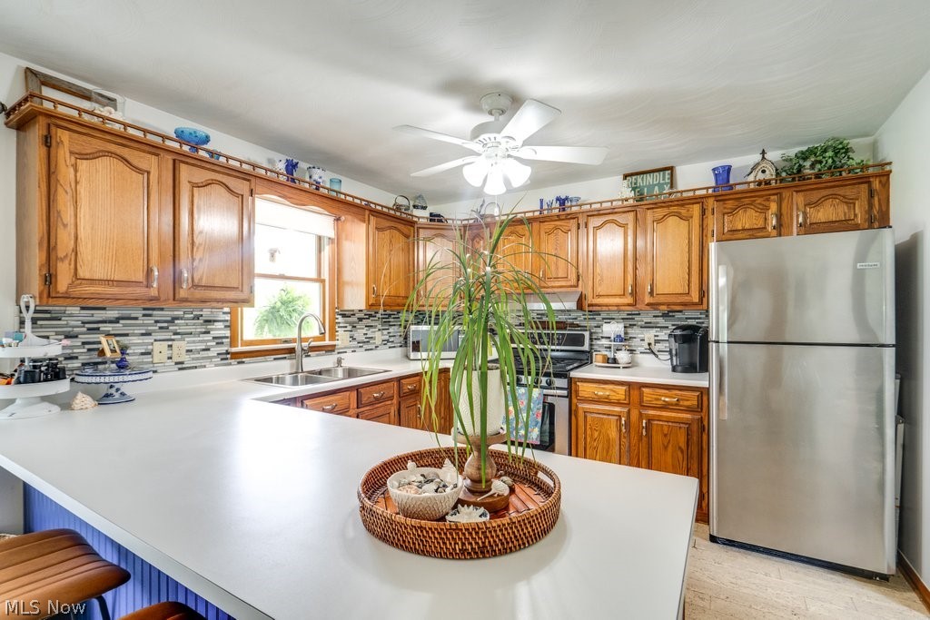 531 Porter Road Atwater, OH 44201 - Photo 27 of 44 Kitchen with appliances with stainless steel finishes, sink, tasteful backsplash, and ceiling fan